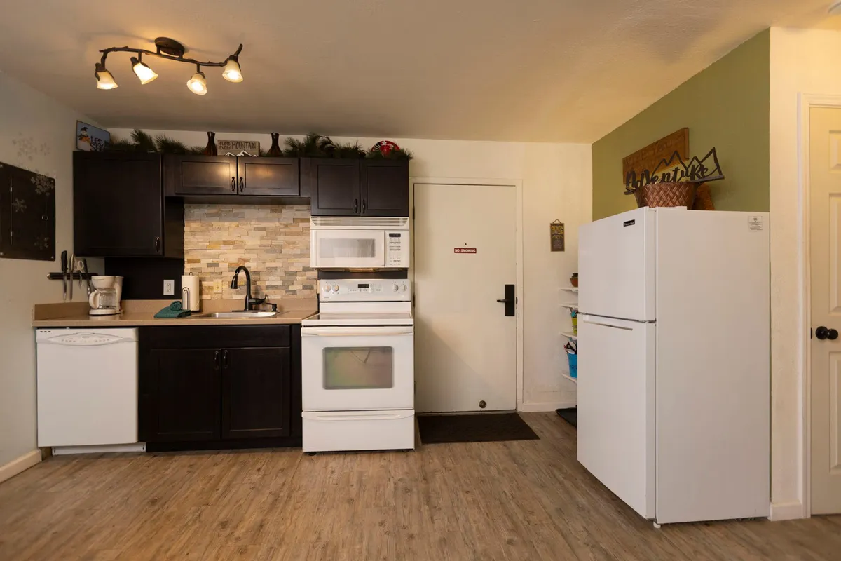 A practical view of the kitchen highlights modern appliances, ample counter space for meal prep, and thoughtful decorative touches. The setup suggests ease of use for cooking and gathering, supporting the idea of sharing meals after a day outdoors.